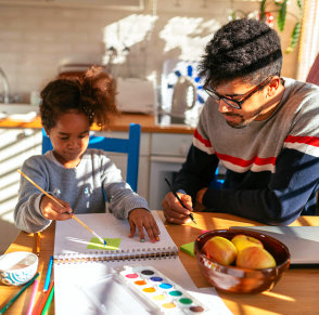 father helping her daughter paint