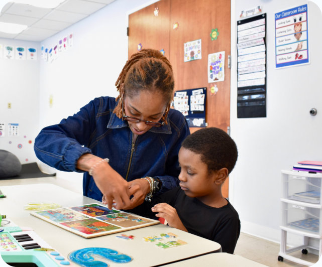 Teacher helping a young boy with a puzzle